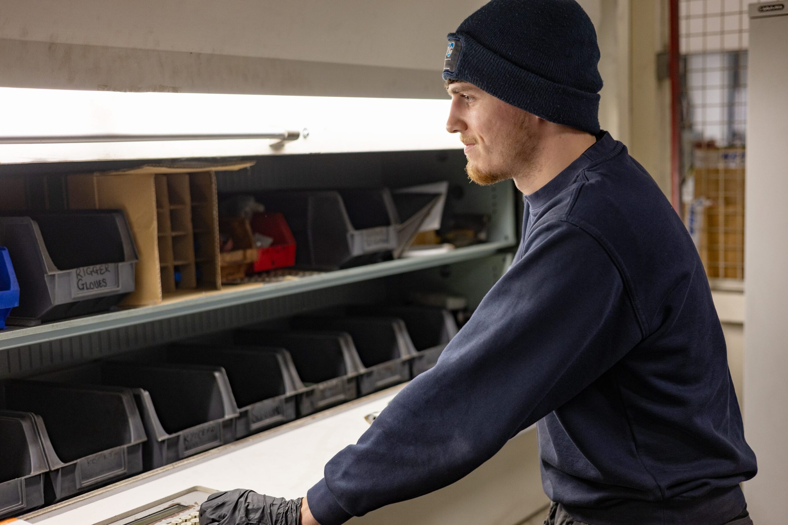 machining worker within the stores department selecting equipment from shelving